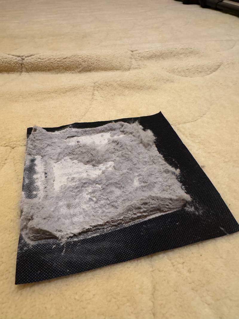 Filter z debelo plastjo posesanega prahu in vlaken na bežni preprogi